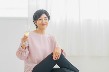 部屋でシャンパンを飲む女性