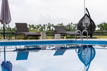 Sun bed chair on the edge of a hotel or resort swimming pool