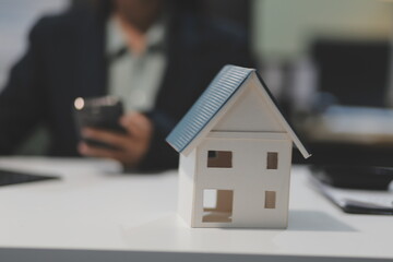 Real estate agents explain models of housing estates in projects to elaborate to clients, explaining and presenting information about homes and purchasing loans. Real estate trading concept.