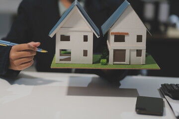Real estate agents explain models of housing estates in projects to elaborate to clients,...