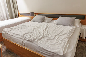 Cozy hotel room with king and twin beds, soft lighting, and neutral decor