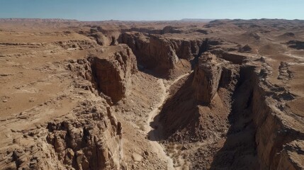 Majestic aerial view of rugged desert canyon landscape under clear blue sky