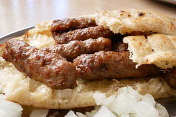 Savoring freshly grilled Cevapi - kebabs wrapped in warm bread at a street food stall during...
