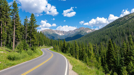 Curvy mountain road surrounded by lush green trees and majestic mountains under bright blue sky with fluffy clouds
