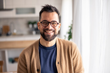 Smiling Man with Glasses Relaxing in Bright Cozy Home with Natural Light