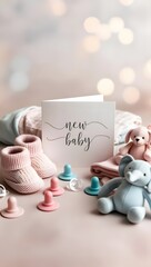 A baby announcement card with new baby hand-lettered, surrounded by soft pastel baby clothes, pacifiers and plush toys