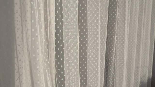 Delicate Mesh Fabric Waving In The Wind. White Dotted Drappery Flutters In The Wind. Curtain Swaying Gently In The Draft. Transparent Curtain Blowing in The Wind. Morning Breeze Swinging The Drapery. 