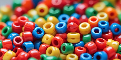 Close-up of colorful plastic pony beads in vivid red, yellow, green, blue, and orange tones, ideal for crafting, DIY jewelry projects, or playful creative design concepts

