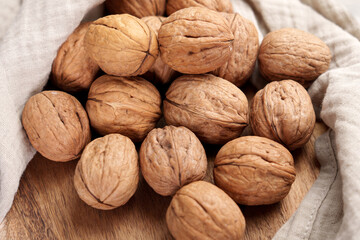 Walnuts on wooden table with crumpled linen cloth napkin. 