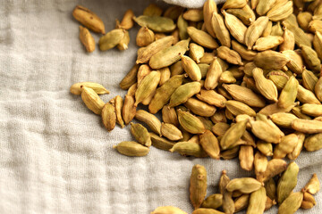 Dried Indian spice cardamom in pods on a cloth napkin close-up