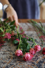 Woman making vibrant, fresh flower bouquet arrangement