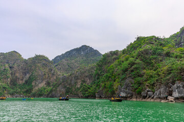 Fototapeta premium Halong Ha Long Bay Hanoi this Vietnamese wonder is littered with mountains and Rock cliffs popping out of the ocean, lush green mountains in Vietnam