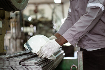 African - black male technician picking up a safety helmet preparing to wear before going to work...