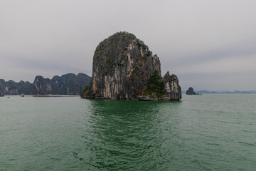 Naklejka premium Halong Ha Long Bay Hanoi this Vietnamese wonder is littered with mountains and Rock cliffs popping out of the ocean, lush green mountains in Vietnam