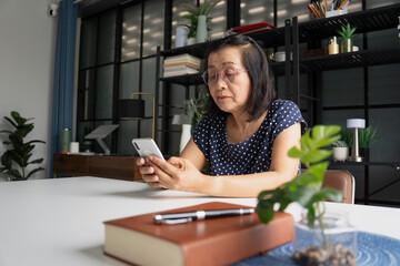 Senior Asian woman holding a smart phone&nbsp;use mobile phone at home