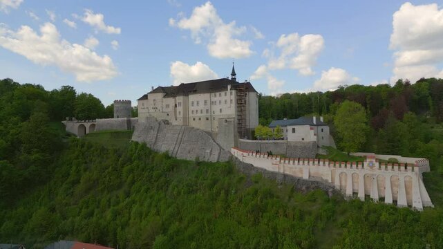 Aerial panoramic view of Cesky Sternberk Castle (Cesky Sternberk, Bohemian Sternberg) surrounded by forested hills and the Sazava river during summer in Czech Republic
