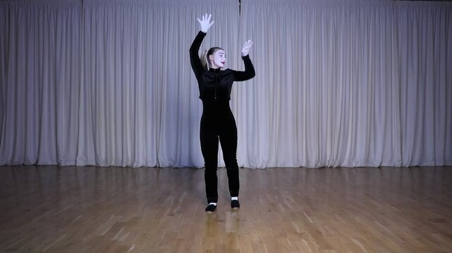 Pantomime of the invisible wall, a mime girl on stage with iridescent colors of light.