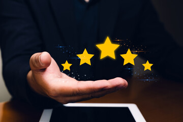 A businessperson hand hovers over a tablet with five glowing gold stars, symbolizing high ratings and excellent service.