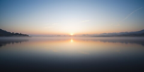 Naklejka premium Misty Sunrise over a Calm Lake