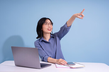 Young Asian woman enthusiastically pointing while engaged in a creative brainstorming session at a...