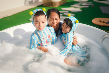 Elderly people playing in the water with small child 
