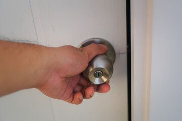 Asian man hand open door knob 
