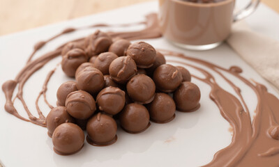 Rich mocha mousse cream splash over a truffle display A luscious splash of mocha mousse cream flowing over an
