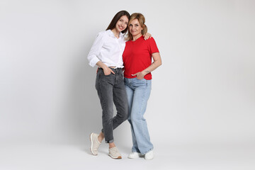 Beautiful mother and daughter on white background