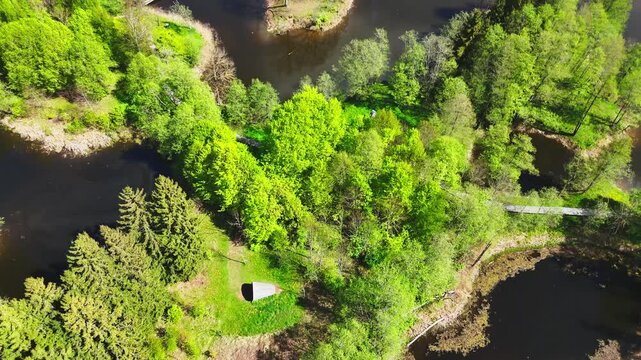 A Peaceful Island Connected by Winding Bridges Sits Amid the Karst Lakes of Kirkilai, Biržai Regional Park, Lithuania - Aerial Drone Shot