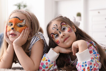 Cute girls with colorful face paintings indoors