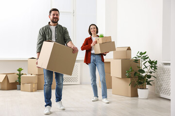 Moving day. Happy couple with their belongings in new home