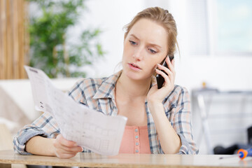 a female on the phone while holding plans