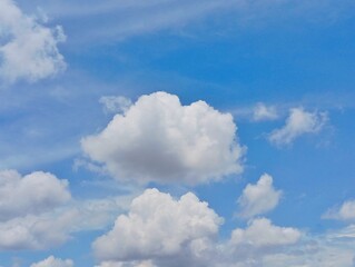 Puffy White Cumulus Cloud on a Clear Blue Sky. Bright Summer Day Cloudscape Background. Serene Sky...