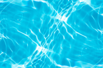 Blue water with ripples on the surface. Defocus blurred transparent blue colored clear calm water surface texture with splashes and bubbles. Water waves with shining pattern texture background.