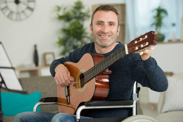 Obraz premium portrait of man in wheelchair holding guitar