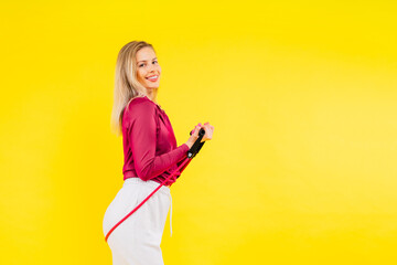 Sports woman in fashion sportswear exercising with elastic band in studio