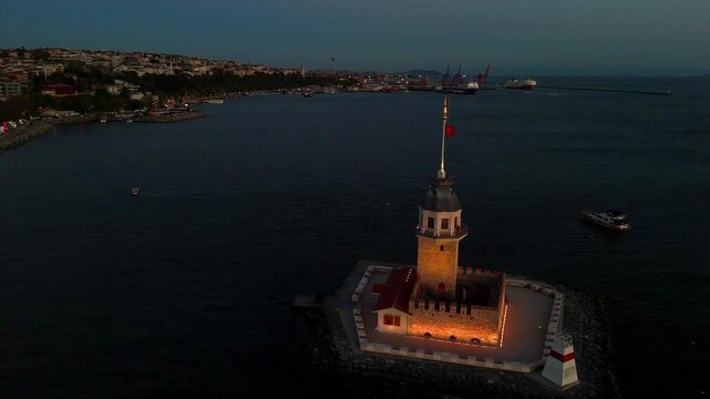 Illuminated Kiz Kulesi at Dusk in Istanbul Harbor. A stunning aerial view of the Maiden's Tower (Leander's Tower) at dusk in Istanbul, Turkey. Turkiye travel holiday toristic 4k ultrahd video tourism