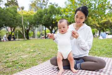 Mother with baby having picnic in park