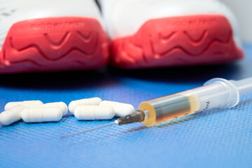 close-up of sneakers and a syringe with a drug for an athlete prepared for administration before...