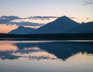Majestic mountains reflect in calm lake during sunset, creating serene and picturesque landscape. vibrant colors of sky enhance tranquil atmosphere of this natural scene