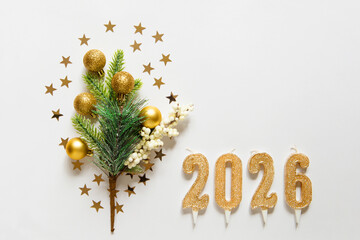 Christmas frame with Christmas tree branch, gold balls, candles 2026 and stars on white background