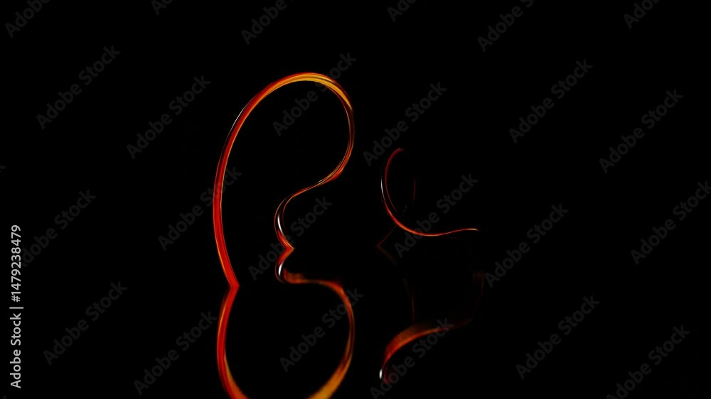 Poster abstract glossy swirling figure of thin round tubes with orange reflections deforms on black backgro