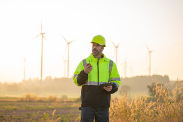 Engineer wearing uniform inspection and survey work in wind turbine farms rotation to generate...