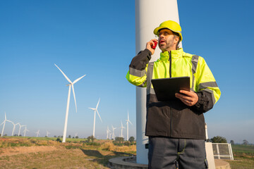 Engineer wearing uniform inspection and survey work in wind turbine farms rotation to generate...