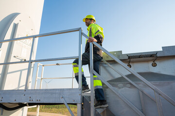 Engineer wearing uniform inspection and survey work in wind turbine farms rotation to generate...