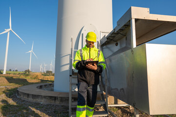 Engineer wearing uniform inspection and survey work in wind turbine farms rotation to generate...