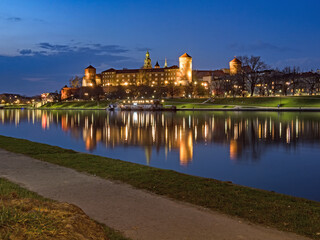 Die historische Wawelburg spiegelt sich zur blauen Stunde im Wasser des Flusses Weichsel, Krakau, Polen