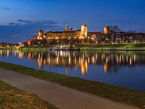 Die historische Wawelburg spiegelt sich zur blauen Stunde im Wasser des Flusses Weichsel, Krakau, Polen