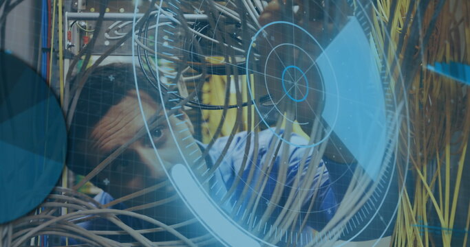 Network technician inspecting colored cable bundles in server rack, with digital overlay