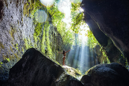 Woman in bikini on a rock, in the forest of Bali, Indonesia
